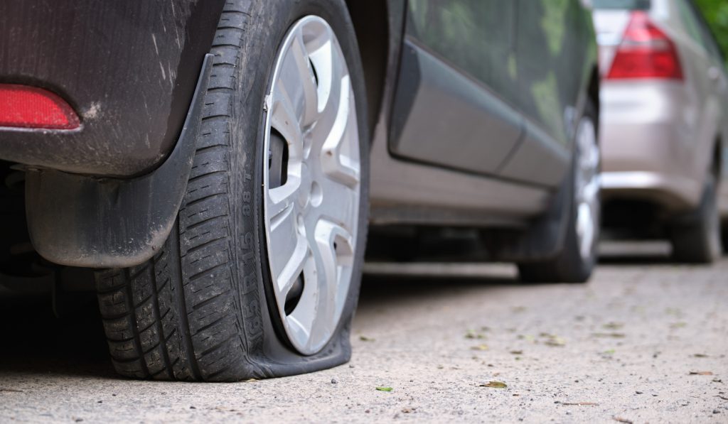 Mobile tire repair service helps fix a flat tire in Fort Collins, Colorado during the day