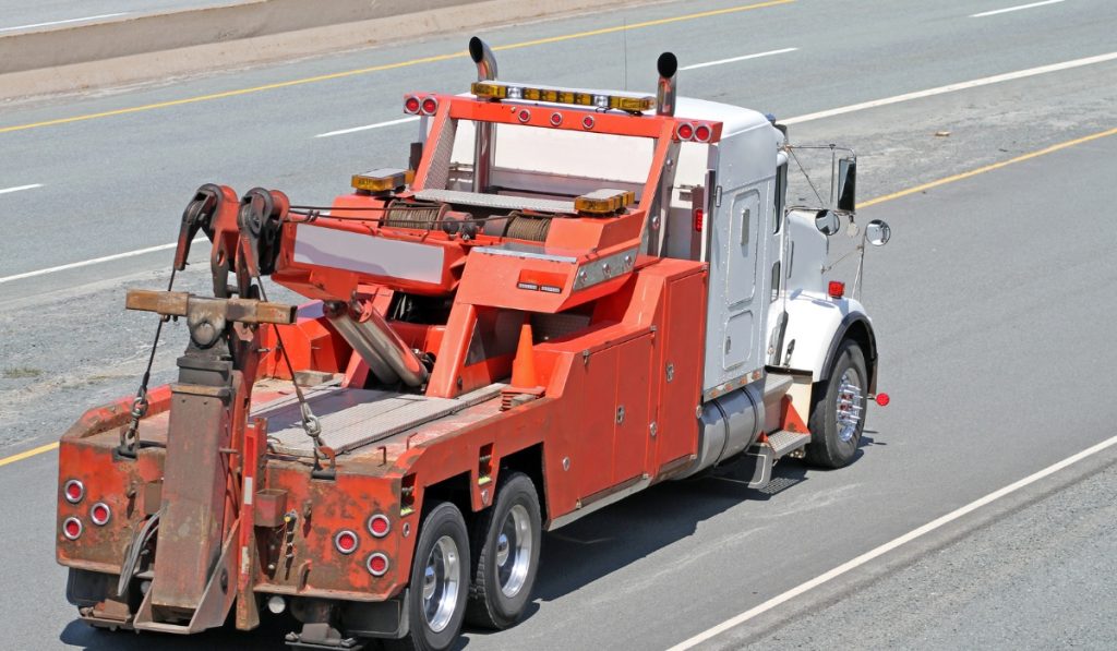 Light duty tow truck transporting a small vehicle